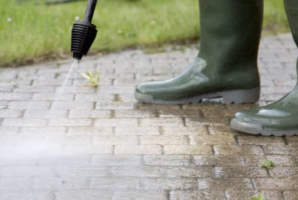 Image of worker power washing outdoor walkway