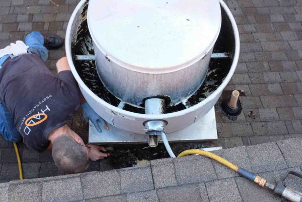 Image of Halo employee cleaning a rooftop grease containment system