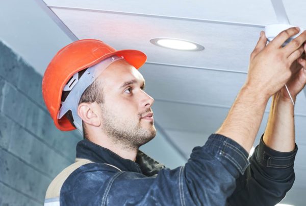 Image of a worker installing a smoke alarm
