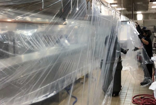 Vent hoods wrapped in plastic with Halo employees