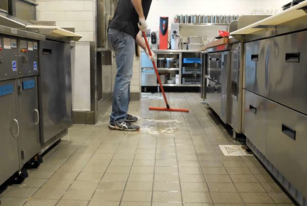 Halo employee mopping kitchen floors during vent a hood cleaning service