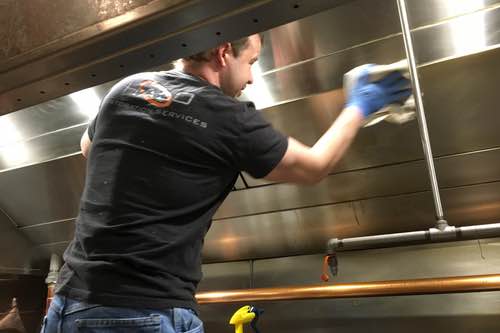 Halo employee polishing the interior of a vent hood canopy