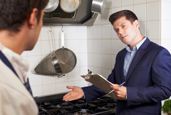 Health inspector meeting with chef in commercial kitchen